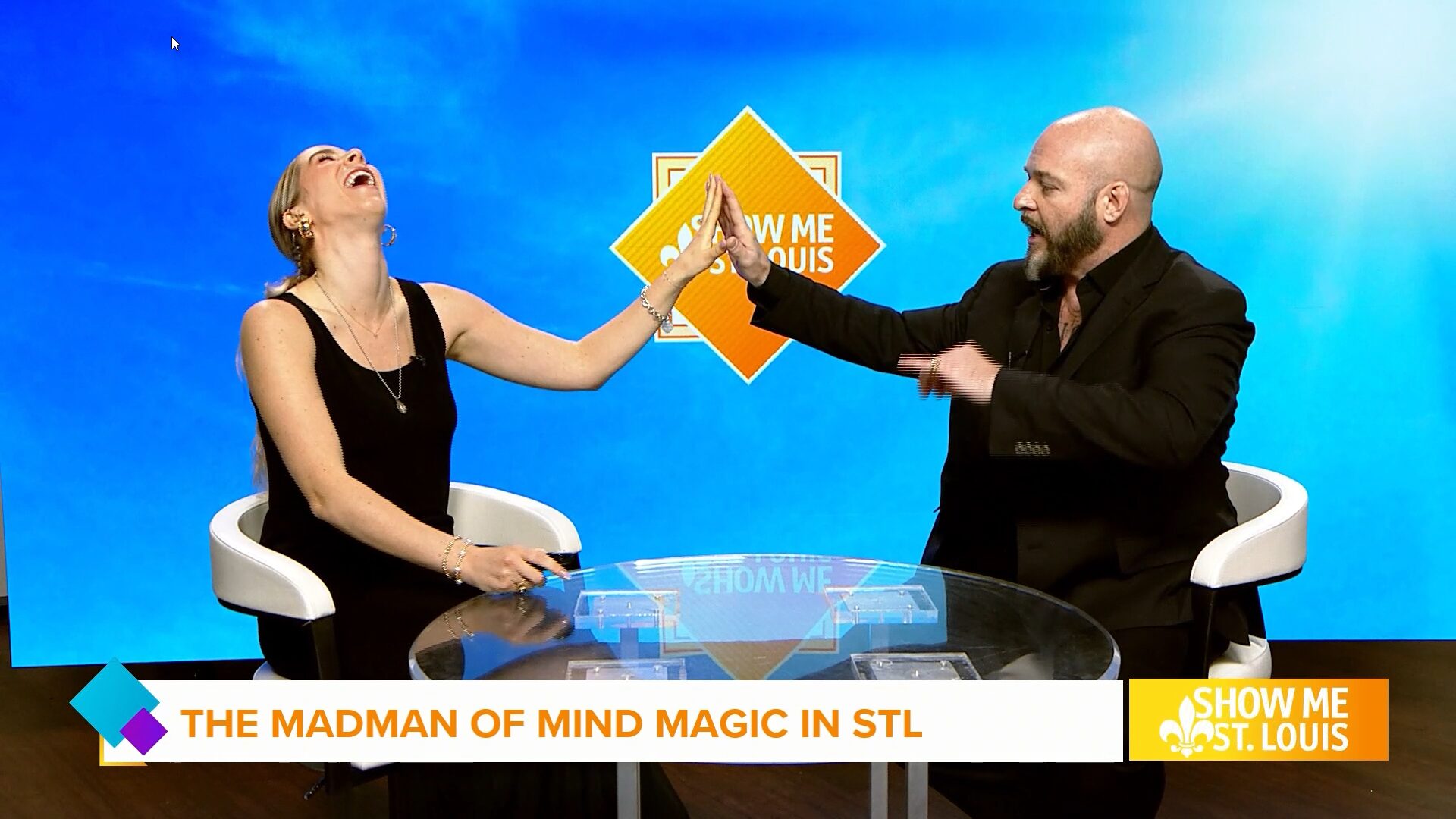 A man and woman touching hands on a television set